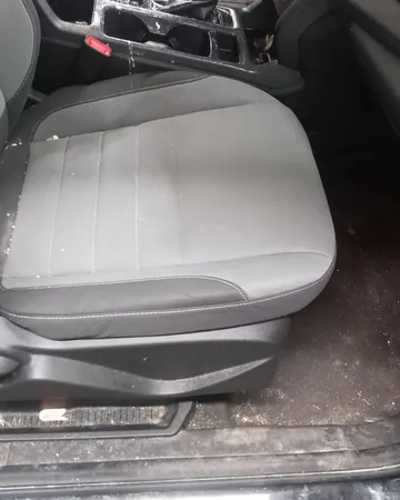Dirty passenger seat with crumbs and a sticky console