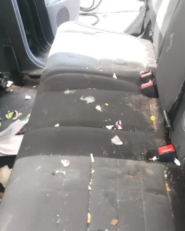 Rear bench seat covered in trash and crumbs